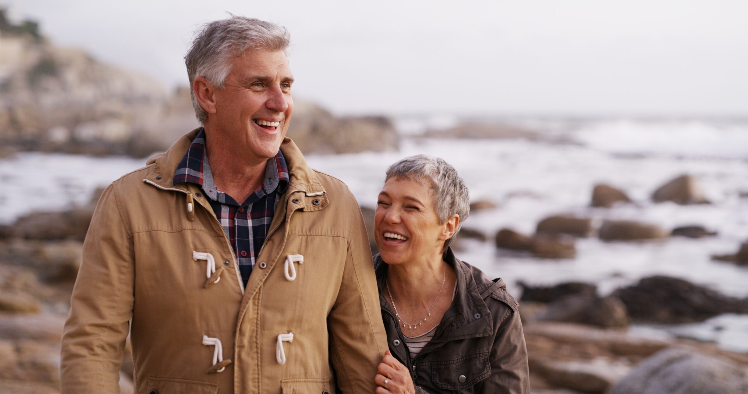 Retired couple walking along the coast